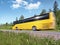Yellow tourist bus on rural highway, motion blur