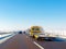 Yellow tow truck with empty platform moves on highway in winter