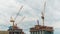 Yellow tower cranes and unfinished building construction