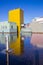 Yellow tower of the museum reflected in the  frozen canal in Groningen