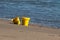 Yellow toy buckets filled with sand left on the beach