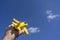 Yellow toy plane flying in to the beautiful blue sky, negative space, concept of going on a magical holiday