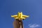 Yellow toy plane flying in to the beautiful blue sky, negative space, concept of going on a magical holiday