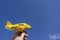 Yellow toy plane flying in to the beautiful blue sky, negative space, concept of going on a magical holiday