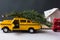 Yellow toy taxi on a tree trunk.