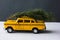 Yellow toy taxi on a tree trunk. Christmas.