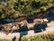 Yellow tracked tractor loads a quarry vehicle with sand. Aerial view