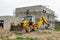 A yellow tractor building a new house