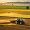 Yellow tractor driving across a large field for harvesting crop in Agricultural vehicle working at golden agronomy and soil