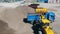 Yellow tractor loads a truck with crushed stones.