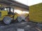 Yellow tractor with shovel at dawn in an industrial waste dump