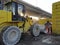 Yellow tractor with shovel parked in a dump at dawn