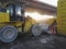 Yellow tractor with shovel parked in an industrial dump at dawn