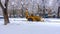 Yellow tractor with snowplow removing snow from the streets