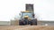 Yellow tractor spreading fertilizer