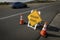 Yellow traffic control sign stating Rough Road on highway shot in late afternoon sun. A car is visible blurred driving past.