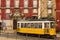 Yellow tram passing by the Azurara Palace. Lisbon. Portugal