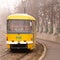 yellow tram rides through the foggy city. alley.paving stones.