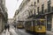 Yellow trams and people in a Lisbon street at dusk