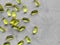 Yellow transparent capsule vitamins pills oval on gray concrete background with copy space