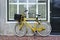 Yellow transport bike parked against renovated house, Amsterdam, Netherlands