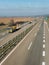 Yellow transportation semi trucks in line on a countryside highway