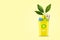 Yellow trash can. With a recycling icon for paper and green sprout with leaves. On a yellow background. Copy space