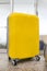 Yellow travel bag with wheels. Modern yellow suitcase