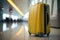 Yellow travel suitcase in airport terminal. Travel concept.