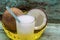 Yellow tray with coconuts and a glass of coconut water