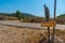 Yellow trekking sign indicating the distance to Milopotamos village in Kythera island in Greece