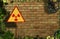 Yellow triangle sign with an international Radioactive Symbol on messy and dirty brick wall background. Digital mock-up