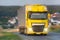 Yellow truck speeding on country road