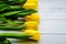Yellow tulips flowers on white wooden background. Waiting for spring. Happy mother`s day, March 8. Flat position, top view. Place