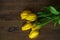 Yellow tulips lie on a wooden background. March 8. women\'s Day. mother\'s day. bouquet of yellow flowers.