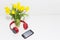 Yellow tulips in a vase with red headphones and a telephone. the concept of romantic music.