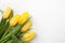 Yellow tulips on white wood background. Spring - poster with free text space.