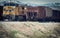 A Yellow Union Pacific Diesel Locomotive Engine And Grain Hopper Cars