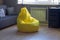 Yellow upholstered bag chair in the interior of a gray dark modern room of a teenage boy or a living room