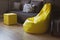 Yellow upholstered bag chair in the interior of a gray dark modern room of a teenage boy or a living room