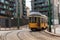 Yellow urban tram runs along the city tracks
