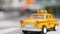Yellow vacant mini taxi cab close up, Harmon corner, Las Vegas, USA. Small retro car model on defocused background