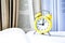 Yellow vintage alarm clock with book on white background, Back to school, Time to learn, wealth knowledge