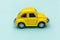 Yellow vintage retro toy car isolated on blue pastel colorful background