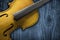 Yellow Violin on grey wooden background. With space for text writing