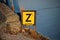 Yellow warning sign with letter `Z ` to warn that a water pipe have sunken on the bottom of the canal.