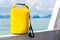 Yellow waterproof bag for travel at the sea