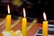 Yellow wax candles are burning at a party, holiday, close up