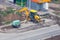 Yellow wheeled excavator digs a trench in the city