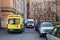 Yellow and white ambulances stand opposite each other in the courtyard